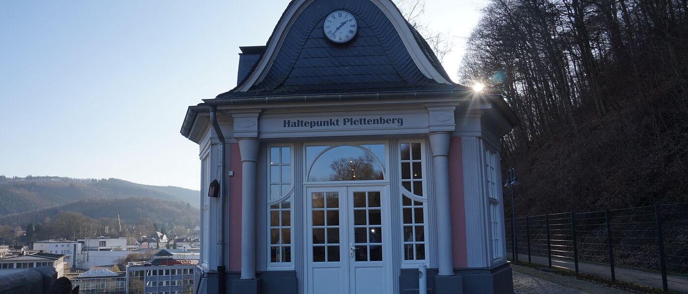 Der klassizistische Pavillon des Café Haltepunkt in der Wintersonne, dahinter der Blick über die Innenstadt von Plettenberg