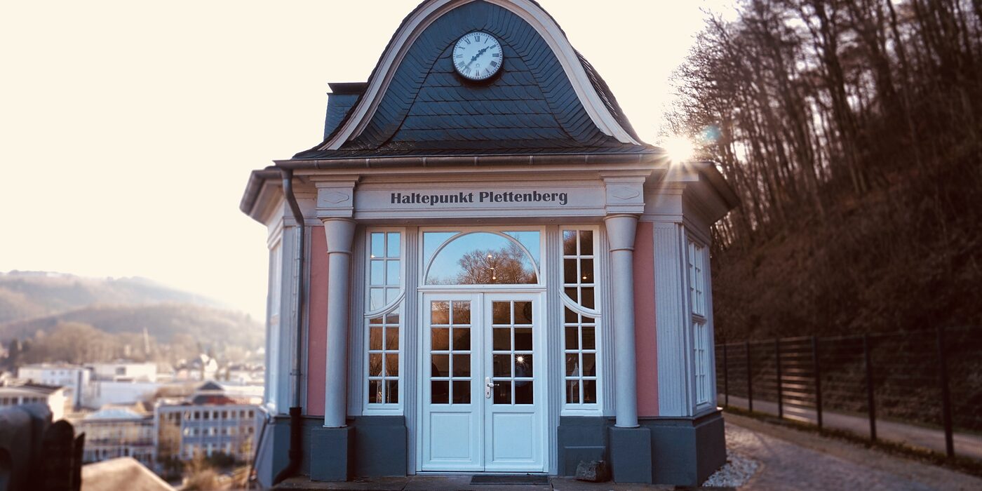 Der klassizistische Pavillon des Café Haltepunkt in der Wintersonne, dahinter der Blick über die Innenstadt von Plettenberg